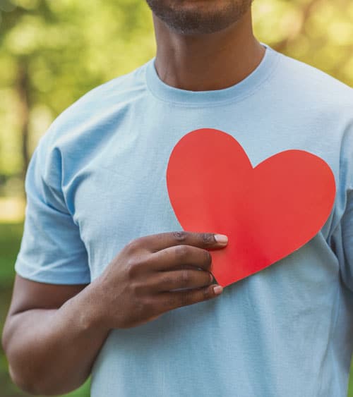 Black man holding red heart on his chest