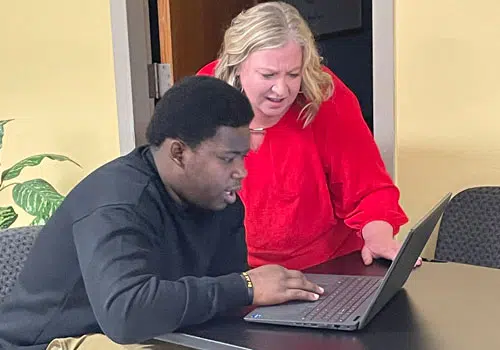 Career Job Opportunities Woman helping young man search for job opportunities on the computer.