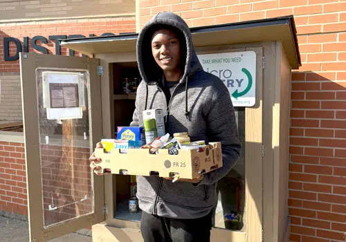 Volunteer youths spend time donating to local micro pantry food boxes.