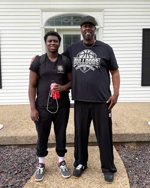 Trey and his Dad, Sam, standing together smiling.