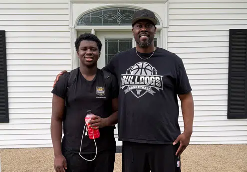 Trey and his Dad, Sam, standing together smiling.