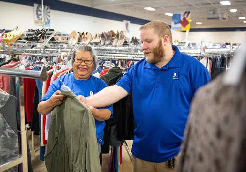 LLGI Goodwill employees and volunteer mark clothes with pricing in store.